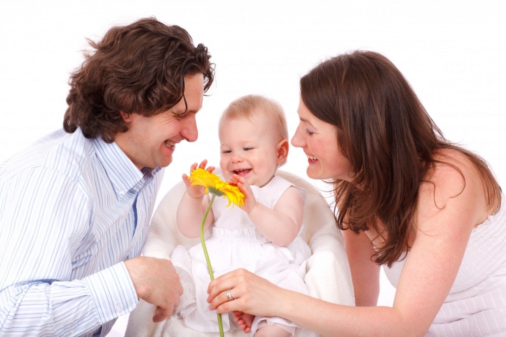 portrait-of-happy-family-with-baby-daughter-playing-with-flower
